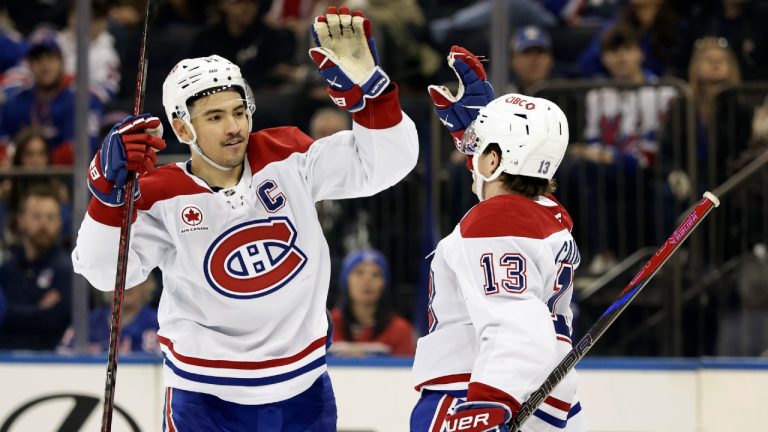 Montreal Canadiens center Nick Suzuki high-fives Cole Caufield (13) after a goal by Caufield in the third period of an NHL hockey game against the New York Rangers Saturday, Nov. 30, 2024, in New York. The Rangers won 4-3. (Adam Hunger/AP)