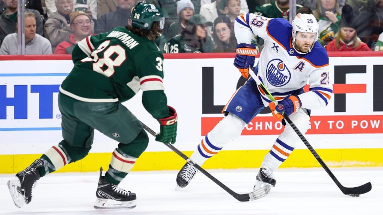 Edmonton Oilers centre Leon Draisaitl, right, skates with the puck as Minnesota Wild right wing Ryan Hartman (38) defends during the second period of an NHL hockey game Thursday, Dec. 12, 2024, in St. Paul, Minn. (Matt Krohn/AP)