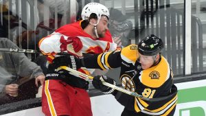 Calgary Flames defenceman Rasmus Andersson, left, and Boston Bruins defenceman Nikita Zadorov, right, slam into the boards in the first period of an NHL game, Thursday, Nov. 7, 2024, in Boston. (AP/Steven Senne)