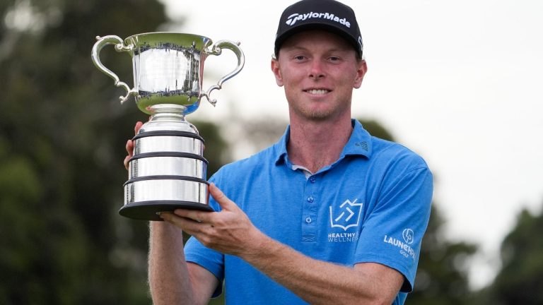 Ryggs Johnston of the United States holds the Stonehaven Cup after winning the Australian Open golf championship at the Kingston Heath Golf Club in Melbourne, Australia, Sunday, Dec. 1, 2024. (AP Photo/Asanka Brendon Ratnayake)