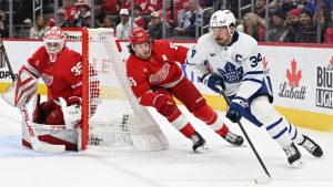 Toronto Maple Leafs center Auston Matthews (34) skates the puck around the Detroit Red Wings goal in front of Red Wings defenseman Moritz Seider (53) during the first period of an NHL hockey game, Saturday, Dec. 14, 2024 in Detroit. (Lon Horwedel/AP)