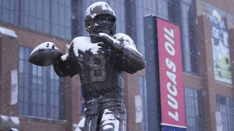 A statue of Peyton Manning by Ryan Feeney is dusted with snow outside Lucas Oil Stadium in Indianapolis.(AP/Michael Conroy)