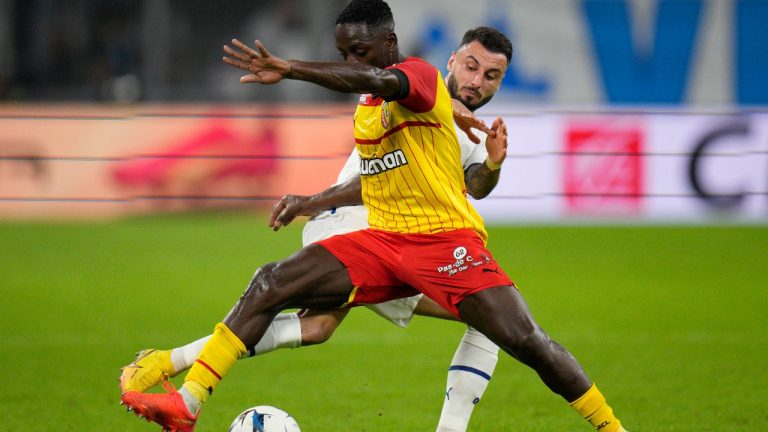 Marseille's Jonathan Clauss vies for the ball with Lens' Deiver Machado, left, during the French League One soccer match between Marseille and Lens at the Velodrome stadium in Marseille, southern France, Saturday, Oct. 22, 2022. (AP Photo/Daniel Cole)