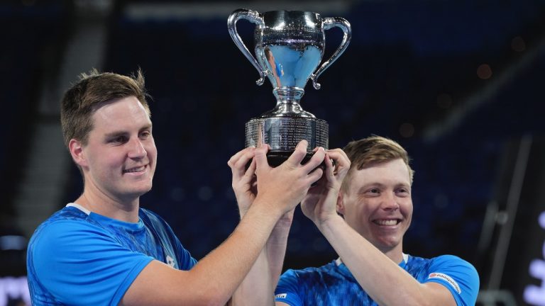 Harri Heliovaara, right, of Finland and Henry Patten of Britain celebrate as they hold their trophy after defeating Italy's Simone Bolelli and Andrea Vavassori in the men's doubles final at the Australian Open tennis championship in Melbourne, Australia, Sunday, Jan. 26, 2025. (AP/Ng Han Guan)