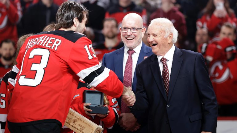 Former New Jersey Devils head coach Jacques Lemaire shakes hands with Devils' Nico Hischier during a ceremony inducting him into the Devils' 'Ring of Honor' before an NHL hockey game against the Boston Bruins, Wednesday, Jan. 22, 2025, in Newark, N.J. (Adam Hunger/AP)