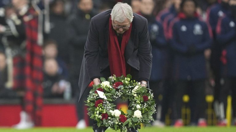 Sir Alex Ferguson observes a tribute to the late Denis Law prior the English Premier League soccer match between Manchester United and Brighton and Hove Albion. (Martin Rickett/PA via AP)