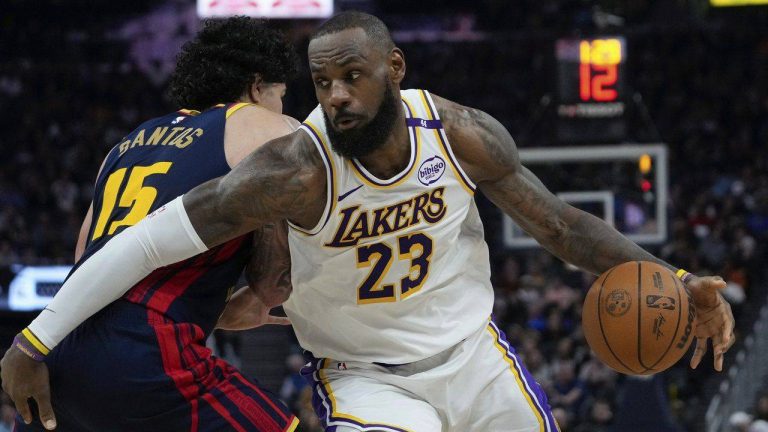 Los Angeles Lakers forward LeBron James, right, moves the ball while defended by Golden State Warriors forward Gui Santos during the first half of an NBA game. (AP Photo/Godofredo A. Vásquez)