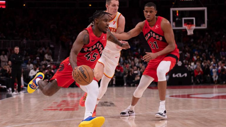 Toronto Raptors guard Davion Mitchell (45) drives the ball past Atlanta Hawks guard Vit Krejci, center, and Raptors center Orlando Robinson (21) during the first half of an NBA basketball game. (Kathryn Skeean/AP)