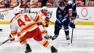 Winnipeg Jets' Gabriel Vilardi carries the puck past Calgary Flames' Jakob Pelletier during the second period of their NHL hockey game in Winnipeg, Sunday, Jan. 26, 2025. (Fred Greenslade/CP)