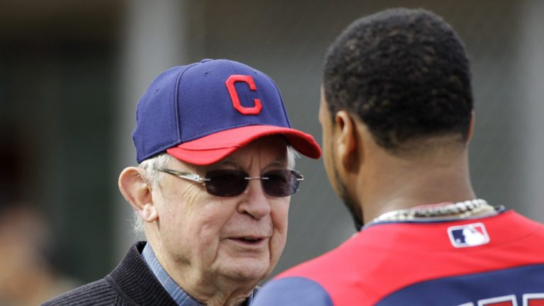 Cleveland Guardians owner Larry Dolan, left, talks with catcher Carlos Santana during baseball spring training Saturday, Feb. 26, 2011, in Goodyear, Ariz. (AP Photo/Mark Duncan)