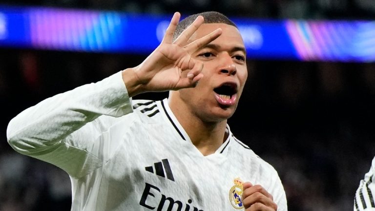 Real Madrid's Kylian Mbappe celebrates with Real Madrid's Jude Bellingham, right, after scoring his sides third goal during the Champions League playoff second leg soccer match between Real Madrid and Manchester City at the Santiago Bernabeu Stadium in Madrid, Spain, Wednesday, Feb. 19, 2025. (Manu Fernandez/AP)