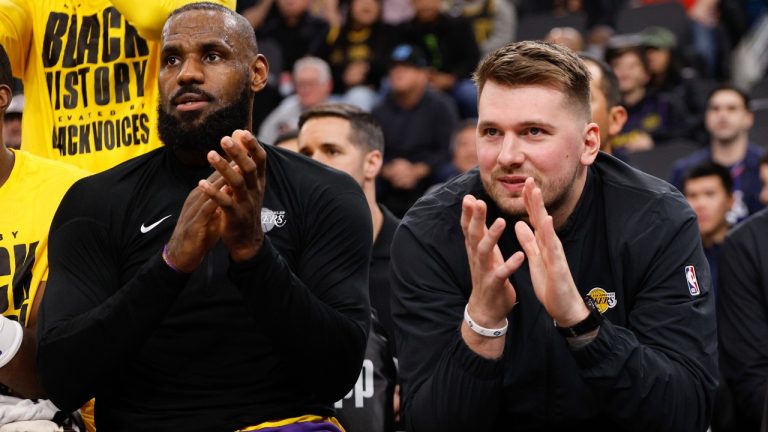 Los Angeles Lakers guard Luka Doncic, right, sits next to forward LeBron James on the bench before an NBA basketball game against the Los Angeles Clippers. (Kevork Djansezian/AP)