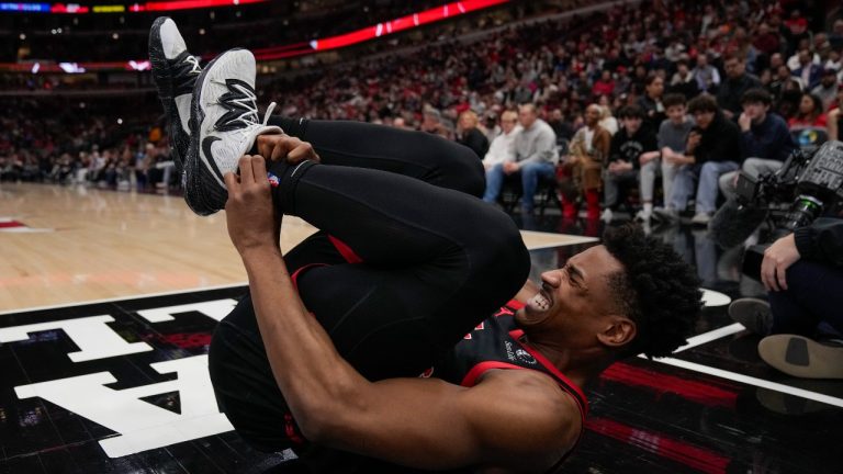 Toronto Raptors guard Ochai Agbaji (30) grabs his ankle as he rolls on the floor during the first half of an NBA basketball game against the Chicago Bulls, Friday, Feb. 28, 2025, in Chicago. (AP Photo/Erin Hooley)