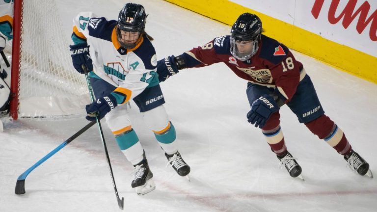 Montreal Victoire's Mikyla Grant-Mentis battles with New York Sirens' Ella Shelton during second period PWHL hockey action in Laval, Que. Saturday February 15, 2025. (Peter McCabe/CP)