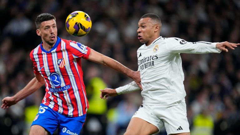 Atletico Madrid's Clement Lenglet vies for the ball with Real Madrid's Kylian Mbappe, right, during a Spanish La Liga soccer match between Real Madrid and Atletico Madrid at the Santiago Bernabeu stadium in Madrid, Saturday, Feb. 8, 2025. (AP Photo/Manu Fernandez)