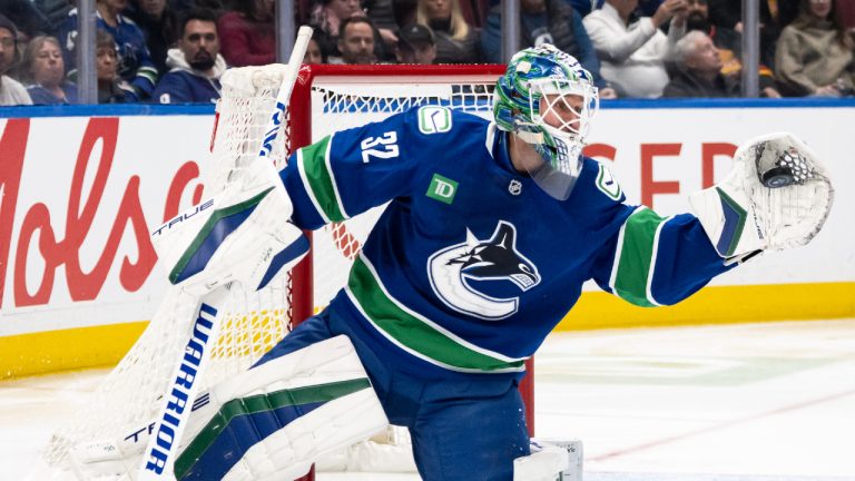 Vancouver Canucks goaltender Kevin Lankinen (32) stops the puck against the Toronto Maple Leafs during the second period of an NHL hockey game in Vancouver, on Saturday, February 8, 2025. (Ethan Cairns/CP)