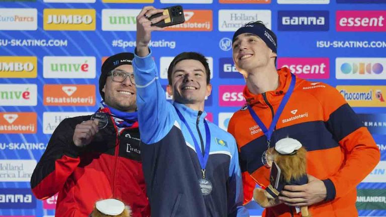 500-metre race winner Yevgeniy Koshkin of Kazakhstan takes selfie on the pdoium with second-place Laurent Dubreuil of Canada, left, and third-place Jenning De Boo of the Netherlands during World Cup Speedskating at the Thialf ice arena in Heerenveen, northern Netherlands, Sunday, March 2, 2025. (Peter Dejong/AP)