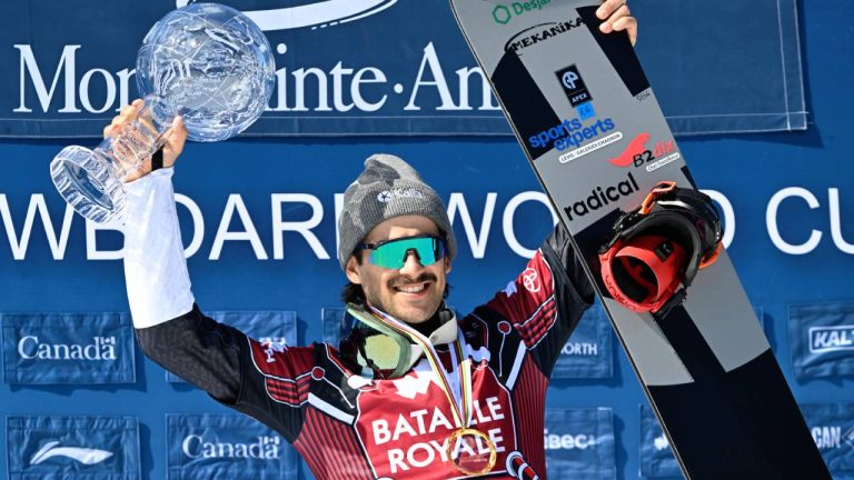 Eliot Grondin of Sainte-Marie, Que. raises the Crystal Globe as the season’s overall winner, Sunday, March 24, 2024 at the FIS snowboard cross world cup event in Beaupre, Que.(CP/Jacques Boissinot)