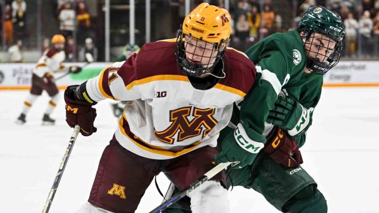 Minnesota forward Oliver Moore, left, and Bemidji State defenceman Mitch Wolfe battle for control of the puck during the second period of an NCAA hockey game on Thursday, Nov.14, 2024 in Minneapolis. (Craig Lassig/AP)