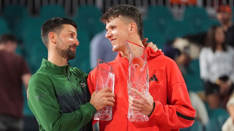 Jakub Mensik, of Czech Republic, holds the Butch Buchholz Championship Trophy after defeating Novak Djokovic, of Serbia, left, in the men's singles final match at the Miami Open tennis tournament, Sunday, March 30, 2025, in Miami Gardens, Fla. (Rebecca Blackwell/AP)