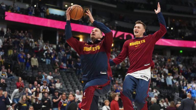 Denver Nuggets center Nikola Jokic (15) jokes with Denver Nuggets guard Christian Braun (0) before the first half of an NBA basketball game. (David Zalubowski/AP)