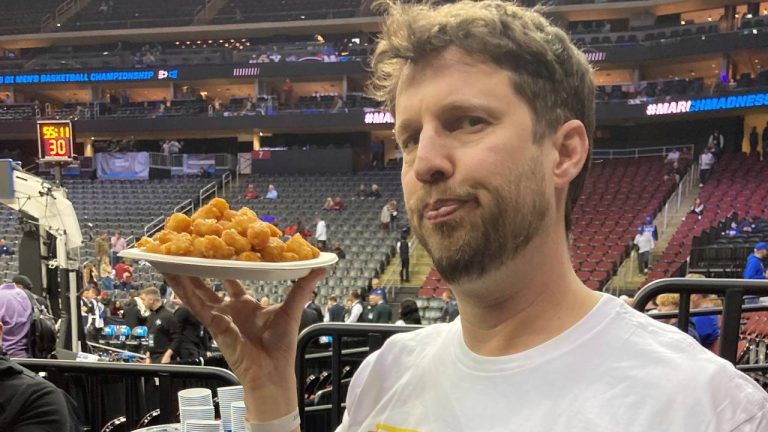 Actor Jon Heder prepares to serve a plate of tater tots ahead of BYU's game in the NCAA college basketball tournament. (Dan Gelston/AP)
