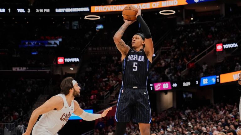 Orlando Magic forward Paolo Banchero (5) shoots over Cleveland Cavaliers guard Max Strus, left, in the second half of an NBA basketball game. (Sue Ogrocki/AP)