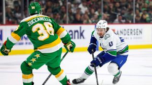 Vancouver Canucks defenceman Quinn Hughes, right, skates with the puck as Minnesota Wild right wing Mats Zuccarello (36) defends during the first period of an NHL hockey game Saturday, Dec. 16, 2023, in St Paul, Minn. (Matt Krohn/AP)