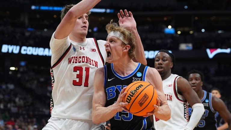 BYU forward Richie Saunders, front right, drives to the basket as Wisconsin forward Nolan Winter (31) defends during the second half in the second round of the NCAA college basketball tournament. (David Zalubowski/AP)
