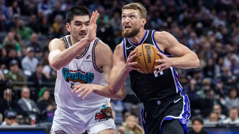 Sacramento Kings center Domantas Sabonis, right, makes a driving layup on Memphis Grizzlies center Zach Edey, left, during the first half of an NBA basketball game Monday, March 17, 2025, in Sacramento, Calif. (Sara Nevis/AP)
