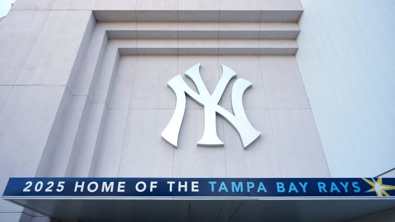 A Tampa Bay Rays banner hangs near a New York Yankees logo outside George M. Steinbrenner Field during a stadium tour. (Chris O'Meara/AP)