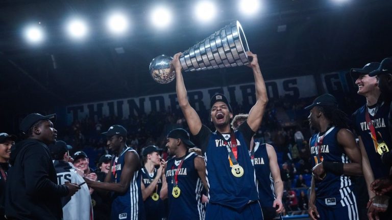 University of Victoria Vikes' Aaron Tesfagiorgis, front right, hoists the trophy after defeating the University of Calgary Dinos during the U Sports men's national basketball championship final, in Vancouver, on Sunday, March 16, 2025. (Darryl Dyck/CP)