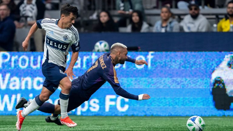 Vancouver Whitecaps' Andres Cubas (20) and Los Angeles Galaxy's Diego Fagundez (7) vie for the ball during the first half of an MLS soccer match in Vancouver, B.C., Sunday, March 2, 2025. (Ethan Cairns/CP)
