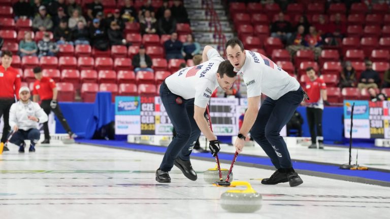 United States' Mark Fenner (right) and Andrew Stopera sweep a stone for skip Korey Dropkin in front of a small crowd at the World Men's Curling Championship in Moose Jaw, Sask. on Sunday, March 30, 2025. (Chris Young/CP)