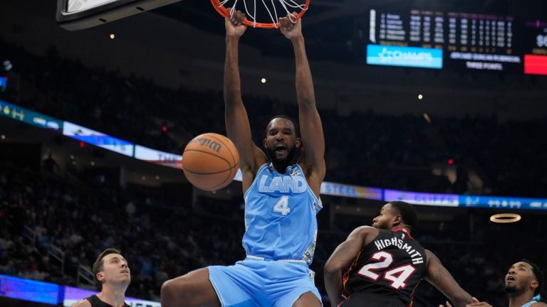 Cleveland Cavaliers forward Evan Mobley (4) dunks between Miami Heat forward Duncan Robinson (55) and forward Haywood Highsmith (24) in the first half of an NBA basketball game Wednesday, March 5, 2025, in Cleveland. (Sue Ogrocki/AP)