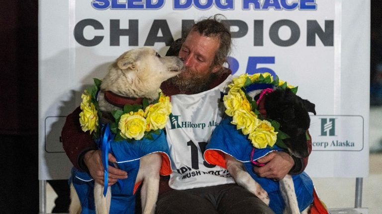 Jessie Holmes hugs his lead dogs Polar, left, and Hercules after winning the Iditarod Trail Sled Dog Race early Friday morning, March 14, 2025 in Nome. (Loren Holme/Anchorage Daily News via AP)