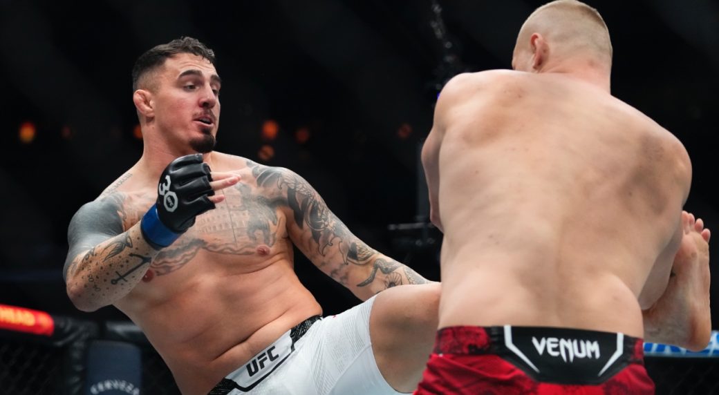 England's-Tom-Aspinall-kicks-Russia's-Sergei-Pavlovich-during-the-first-round-of-their-heavyweight-title-bout-at-UFC-295