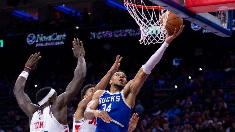 Milwaukee Bucks' Giannis Antetokounmpo, right, goes up for the shot with Philadelphia 76ers' Quentin Grimes, center, and Adem Bona, left, defending during the first half of an NBA basketball game, Thursday, April 3, 2025, in Philadelphia. (AP Photo/Chris Szagola)