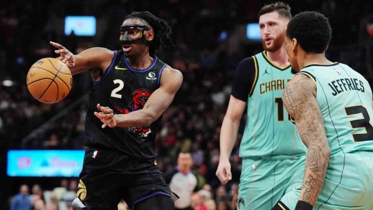 Toronto Raptors' Jonathan Mogbo (2) makes a pass as Charlotte Hornets' Jusuf Nurkic (11) and DaQuan Jeffries (3) look on during second half NBA basketball action in Toronto on Wednesday, April 9, 2025. (Frank Gunn/CP)