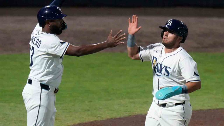 Tampa Bay Rays' Junior Caminero, left, and Jonathan Aranda celebrate after scoring on a two-run double by Christopher Morel off Boston Red Sox pitcher Michael Fulmer during the third inning of a baseball game Monday, April 14, 2025, in Tampa, Fla. (Chris O'Meara/AP)
