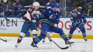 Colorado Avalanche's Artturi Lehkonen (62) checks Vancouver Canucks' Tyler Myers (57) during the first period of an NHL hockey game in Vancouver, on Tuesday, February 4, 2025. (Darryl Dyck/CP)