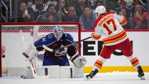 Calgary Flames centre Yegor Sharangovich (17) scores the winning goal against Colorado Avalanche goaltender Scott Wedgewood during a shootout in an NHL hockey game Monday, March 31, 2025, in Denver. (David Zalubowski/AP)