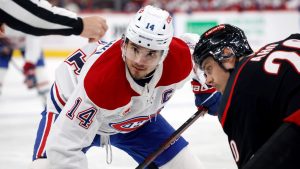 Montreal Canadiens' Nick Suzuki (14) and Carolina Hurricanes' Sebastian Aho (20) watch the puck during a face off during the third period of an NHL hockey game in Raleigh, N.C., Friday, March 28, 2025. (Karl DeBlaker/AP)