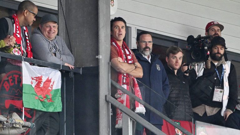 Wrexham co-owner Rob McElhenney, center, watches from the stands during the English Football League One Soccer match between Wrexham and Bristol Rovers, at the SToK Racecourse, Wrexham, Wales, Friday April 18, 2025. (Cody Froggatt/PA via AP)