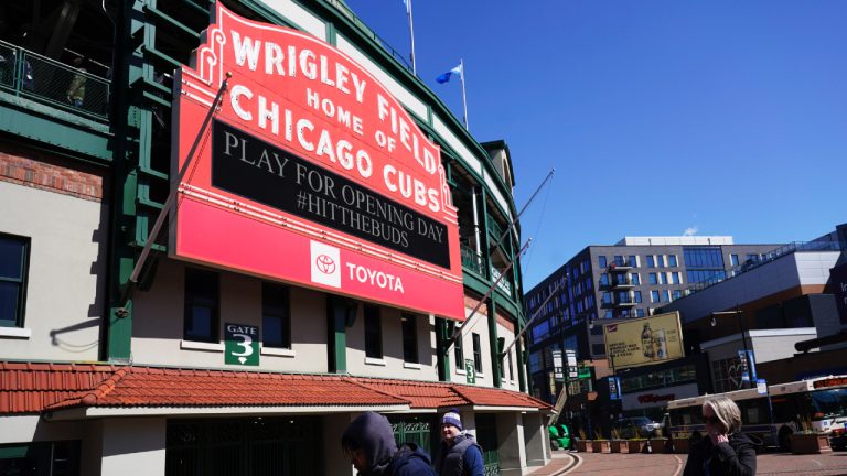 People stand outside Wrigley Field in Chicago, Monday, March 27, 2022, the venue for this Thursday's opening day baseball game between the Milwaukee Brewers and the Chicago Cubs. (Nam Y. Huh/AP)