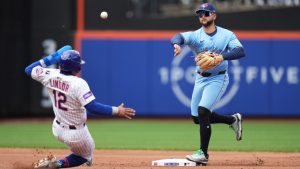 Toronto Blue Jays shortstop Bo Bichette, right, turns a double play over New York Mets' Francisco Lindor during the first inning of a baseball game, Sunday, April 6, 2025, in New York. (Seth Wenig/AP)