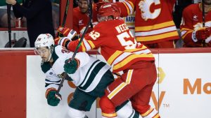 Minnesota Wild's Mats Zuccarello, (36) is checked by Calgary Flames' MacKenzie Weegar (52) during first period NHL hockey action in Calgary on Friday, April 11, 2025. (Jeff McIntosh/THE CANADIAN PRESS)