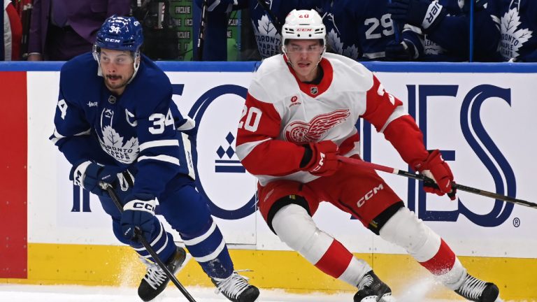Toronto Maple Leafs' Auston Matthews (34) protects the puck from Detroit Red Wings' Albert Johansson (20) during the first period of their NHL hockey game Thursday, April 17, 2025 in Toronto. (on Blacker