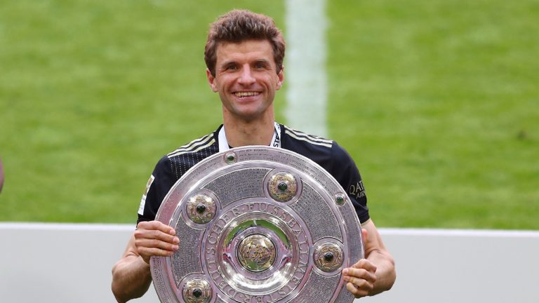 Bayern's Thomas Mueller holds the trophy after winning the Bundesliga title after the German Bundesliga soccer match between Bayern Munich and FC Augsburg at the Allianz Arena stadium in Munich, Germany, Saturday, May 22, 2021. (Matthias Schrader/AP)