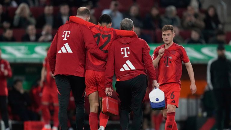 Bayern's Jamal Musiala is helped off the pitch during the German Bundesliga soccer match between Augsburg and Bayern Munich in Augsburg, Friday, April 4, 2025. (Matthias Schrader/AP)